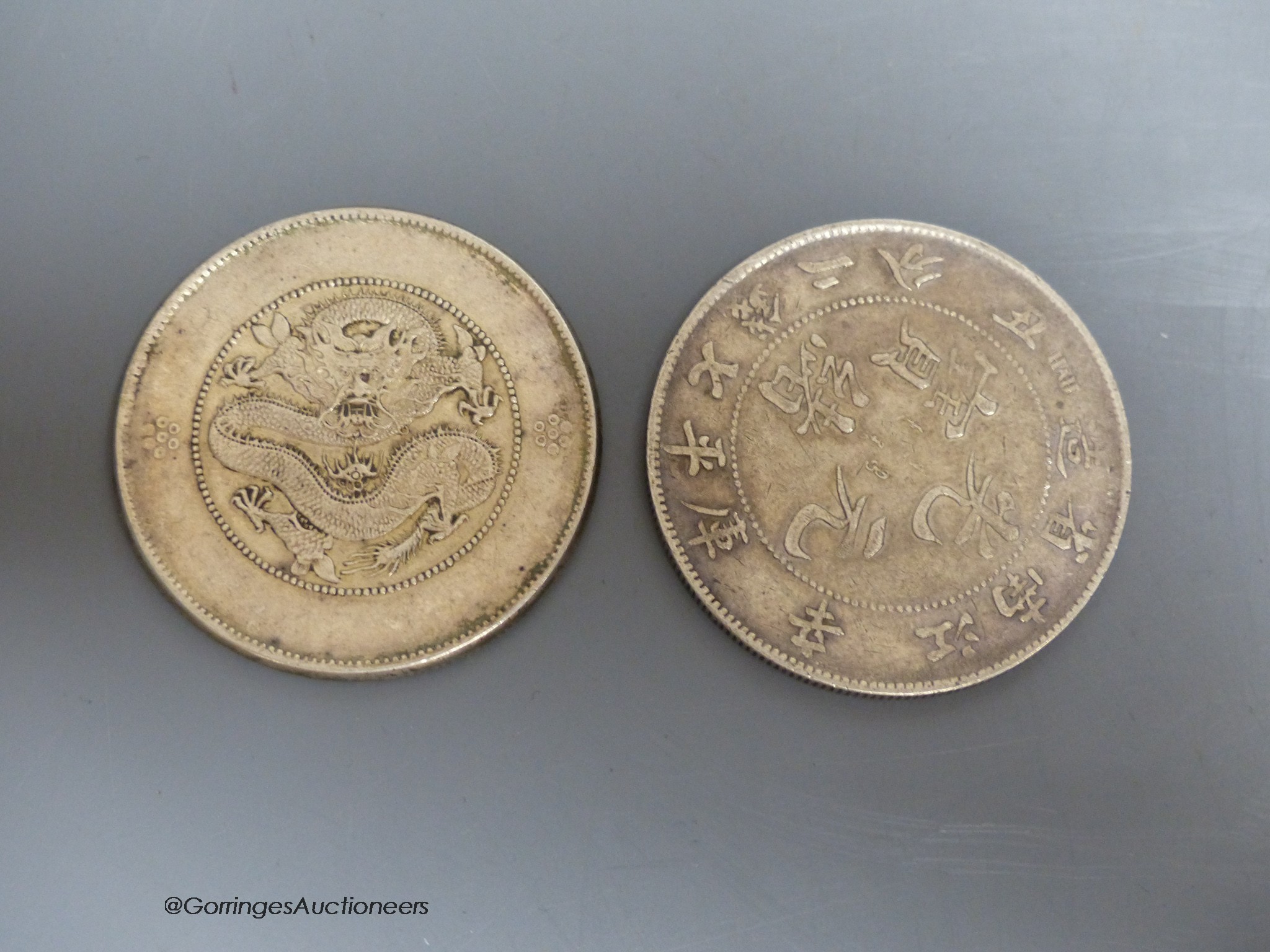 A South East Asian terracotta Buddha's head and two Chinese coins